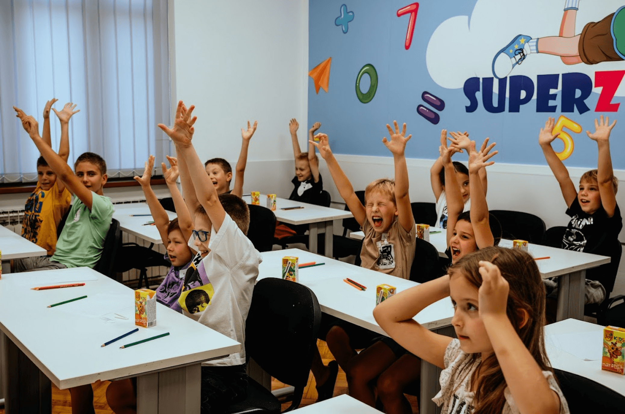 The students in the classroom spread their arms and are happy. 