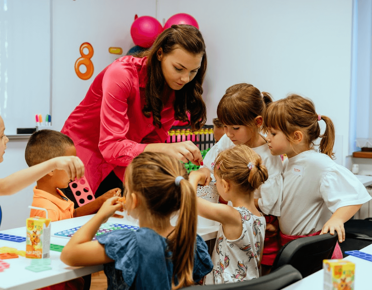 The teacher is educating a group of children.